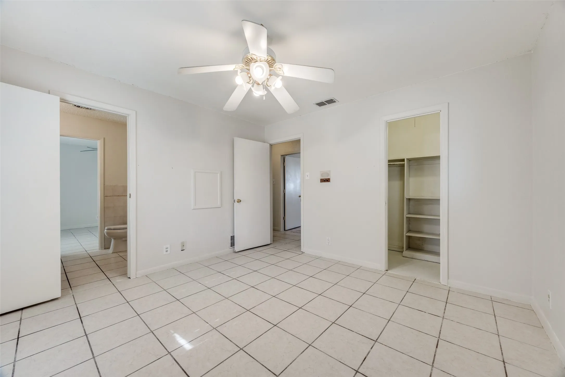 Secondary bedroom enjoys a walk-in closet with built-ins and direct access to the connecting bath.