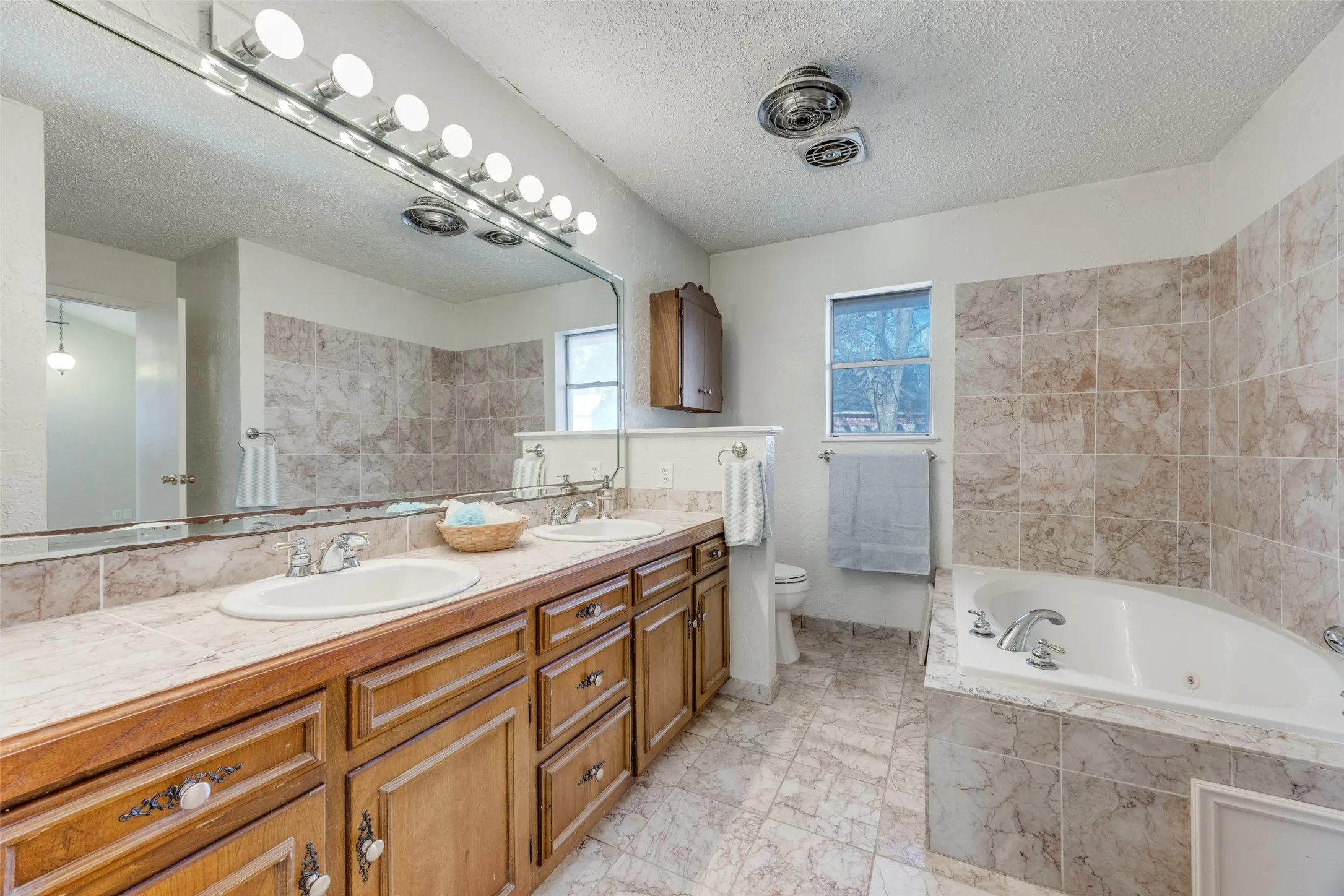 master bath features abundant cabinets, dual vanity, jet tub & separate shower.