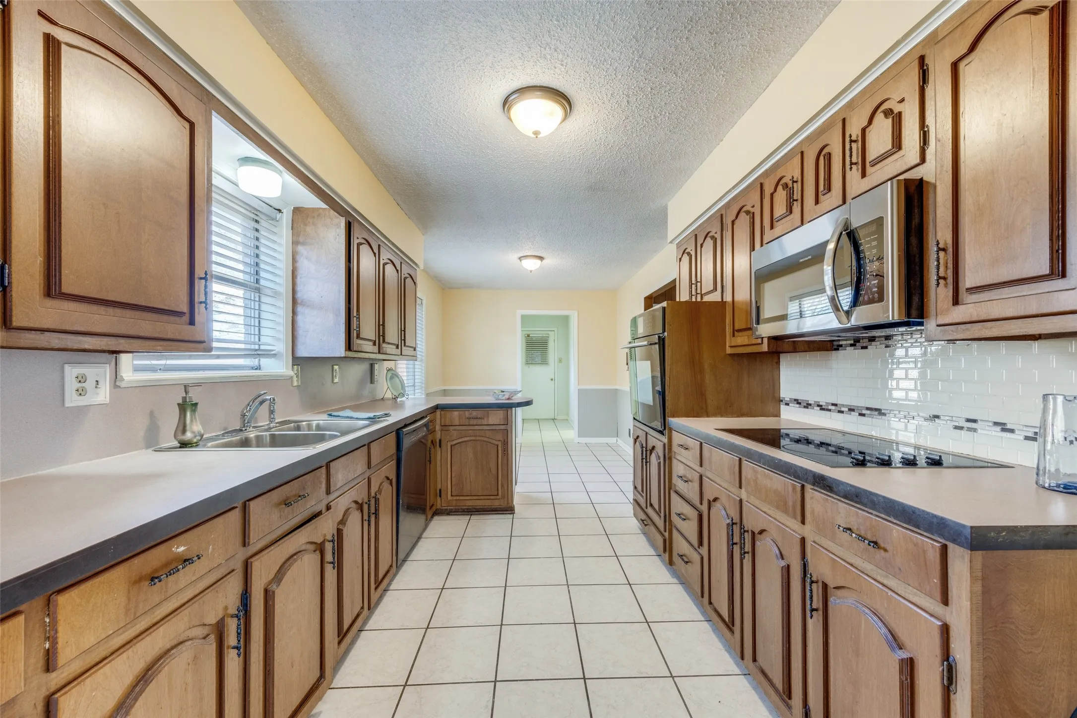 The kitchen features abundant cabinets and small breakfast bar to breakfast area.