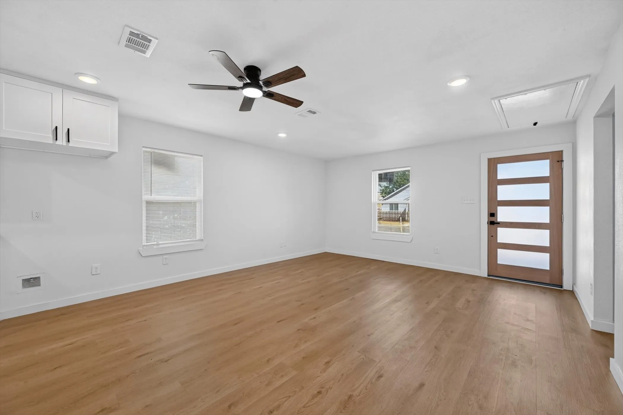 Wood-finish flooring, recessed lighting, and a contemporary ceiling fan with integrated light