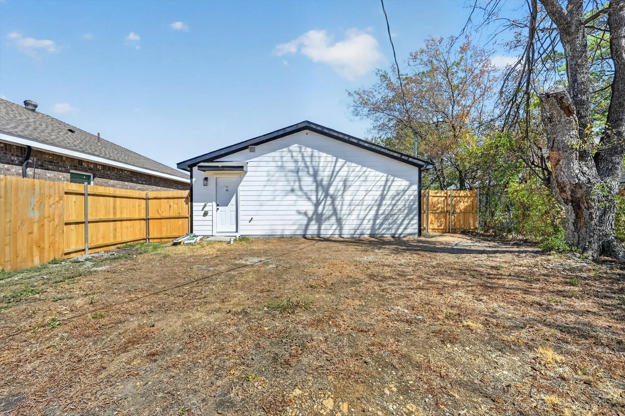 Detached structure with white horizontal siding and black roof