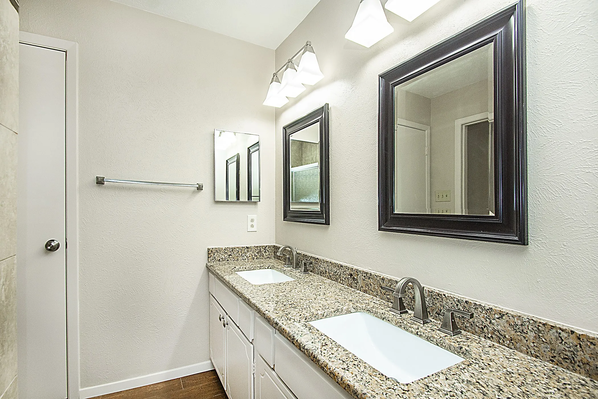 Dual vanity with granite-style countertop, undermount sinks, and brushed nickel fixtures