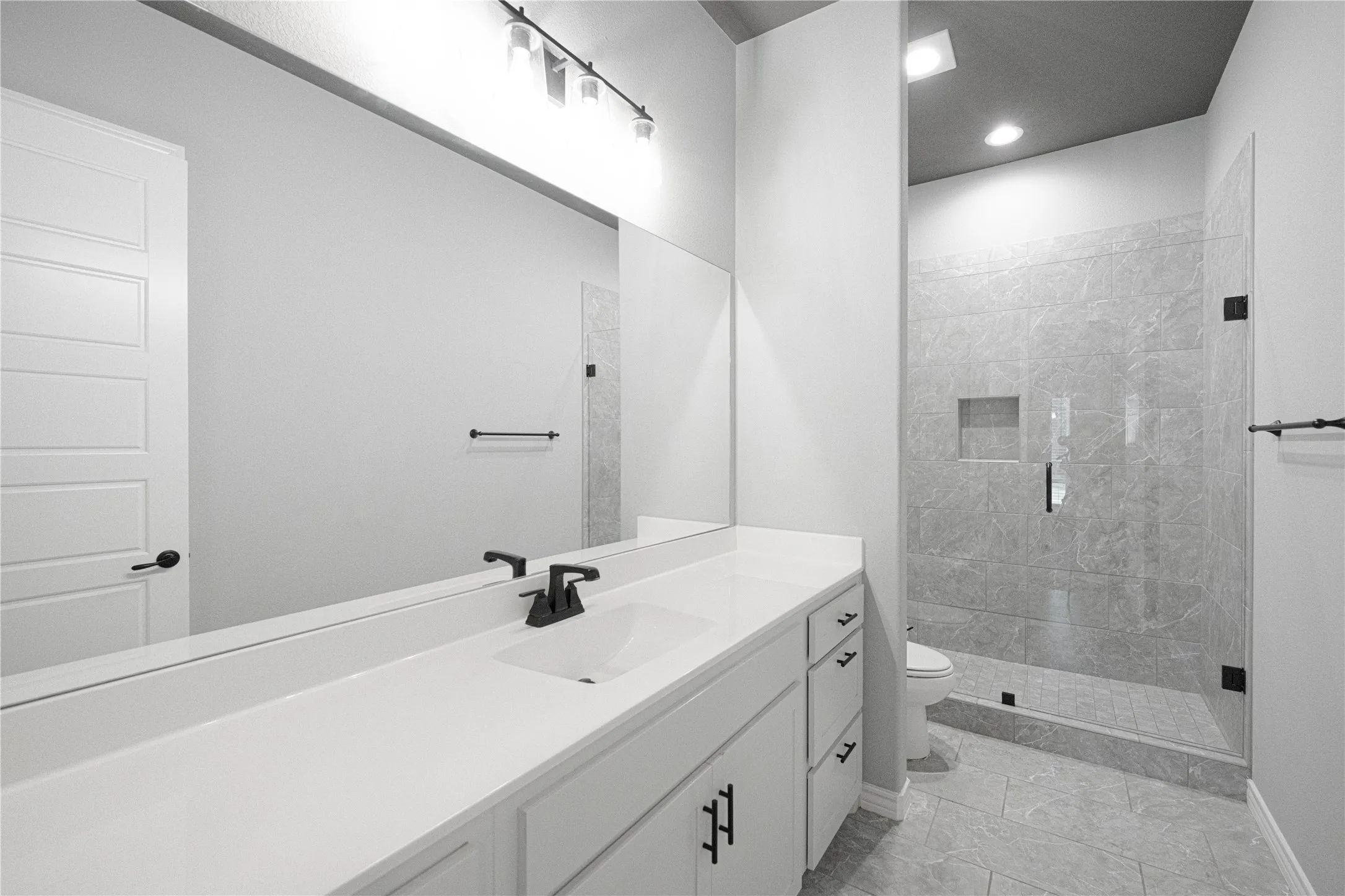 Vanity with a single basin, white countertop, and dark-finish faucet