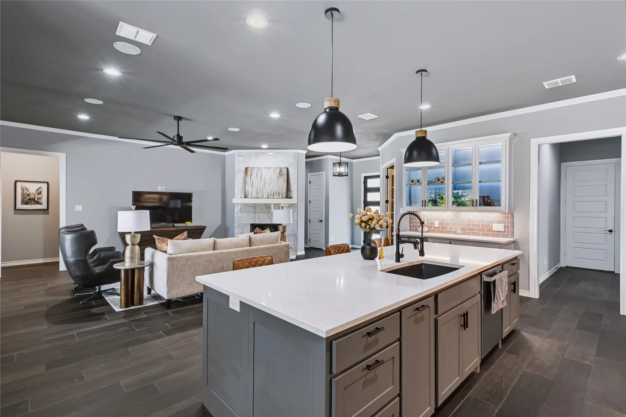 Spacious kitchen island with light-toned countertop, recessed lighting, and wood-finish flooring throughout