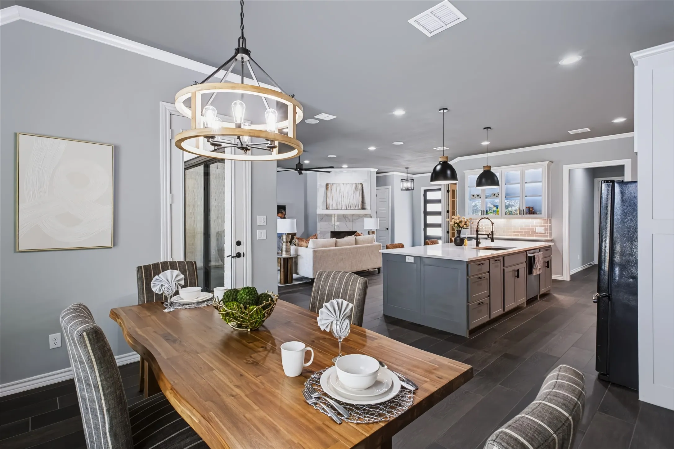 Open-concept layout featuring wood-finish flooring, a kitchen island with seating, pendant lighting, and recessed lighting