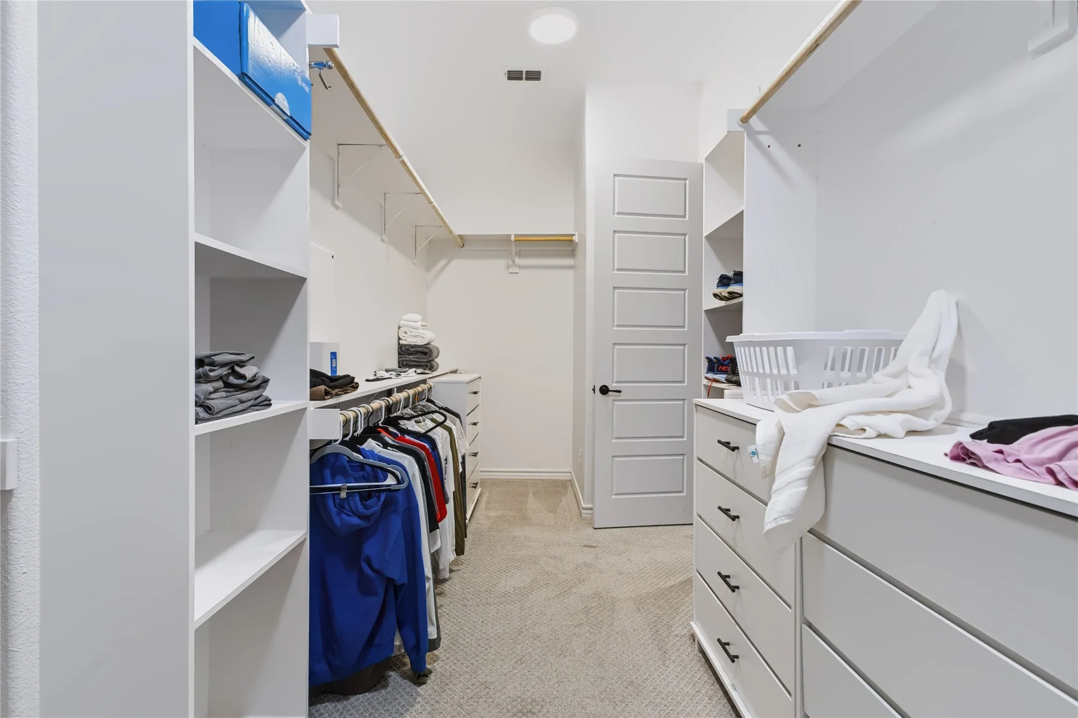 Built-in white storage shelving and hanging rods