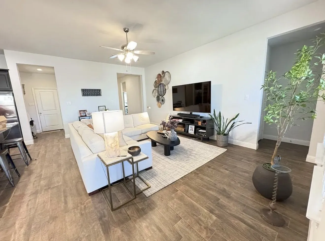 Spacious living area featuring wood-finish tile flooring, recessed lighting, and a ceiling fan