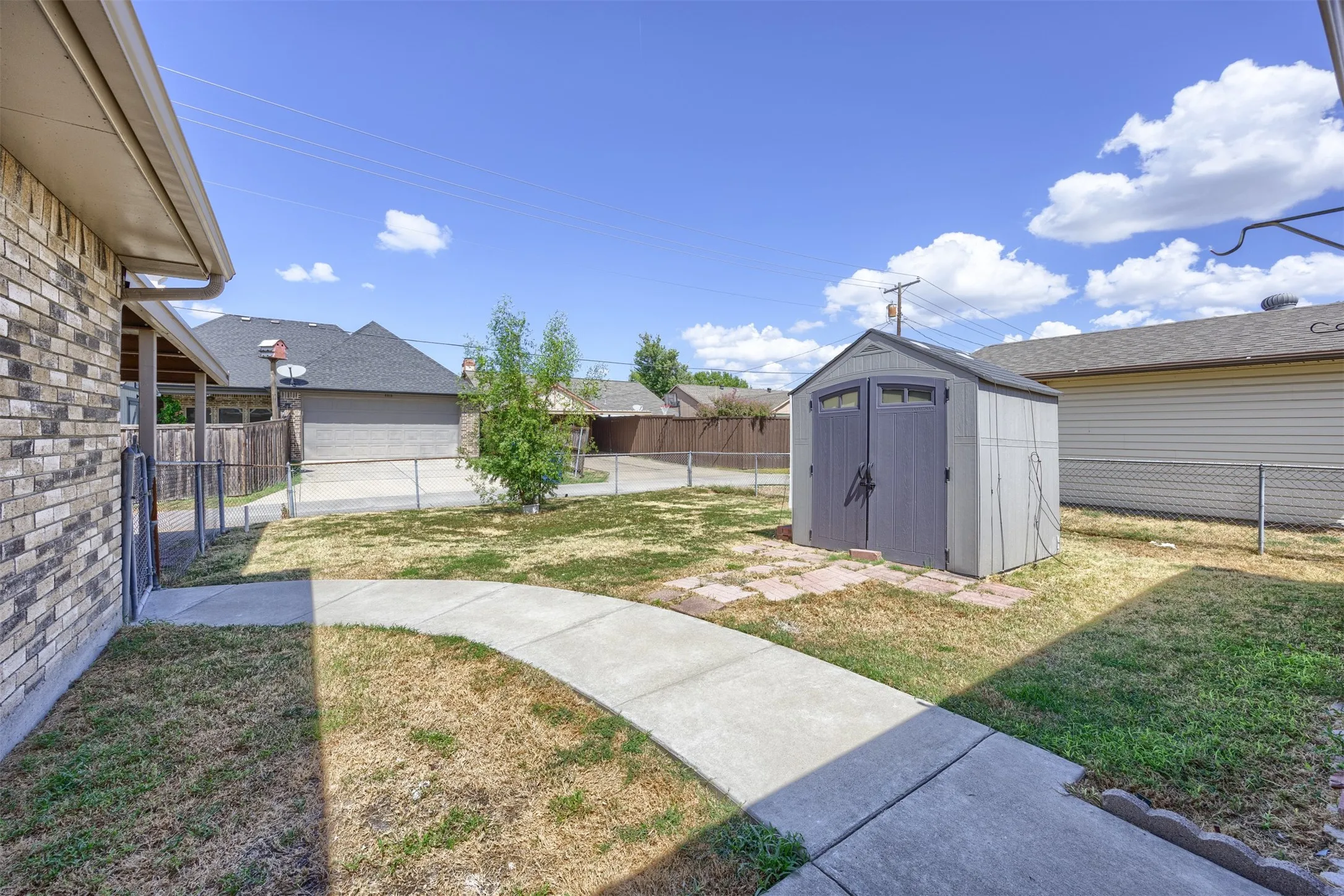 Fenced in back yard with storage shed