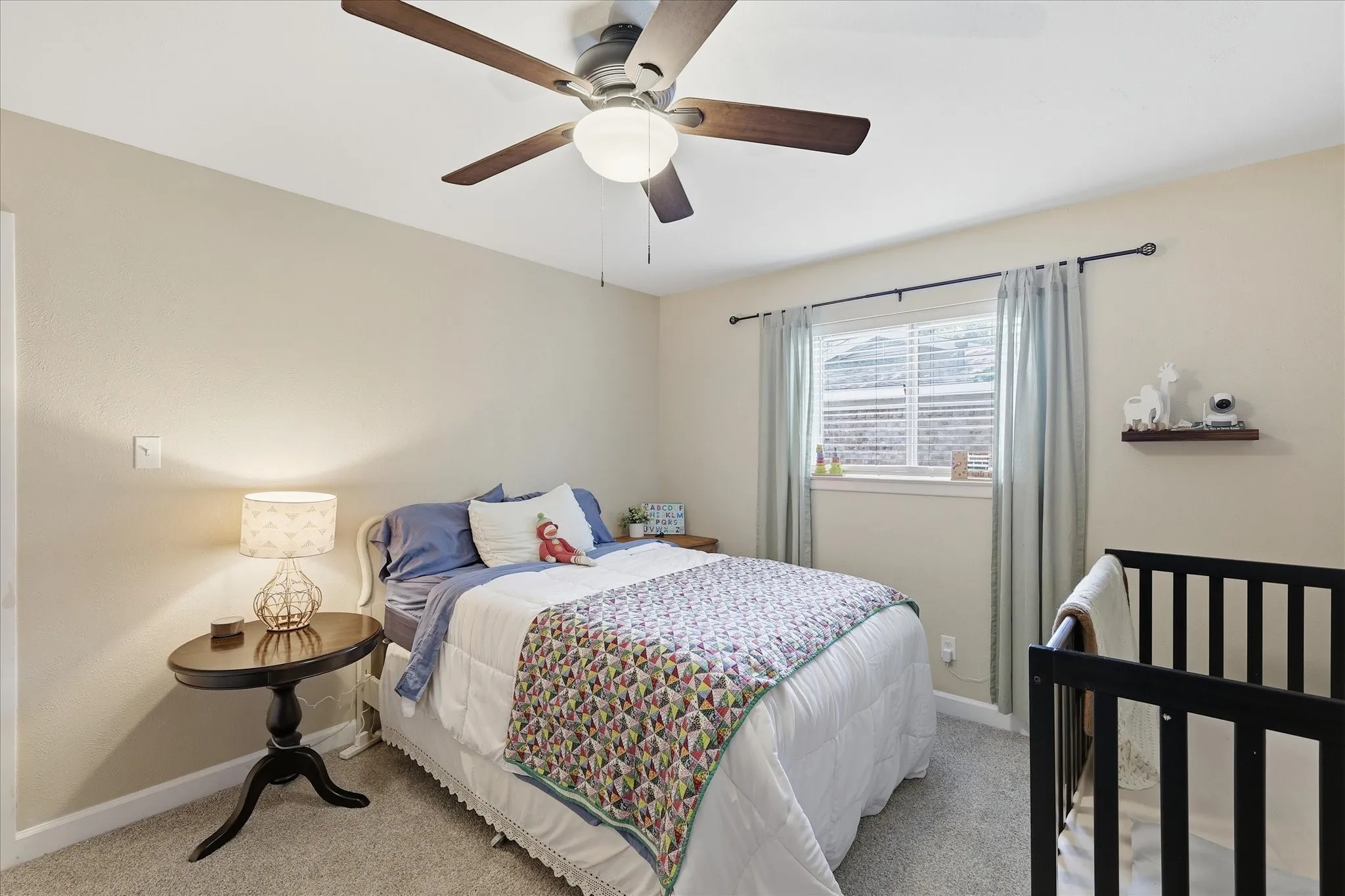 Ceiling fan with light fixture, window with blinds, and wall-mounted shelving unit