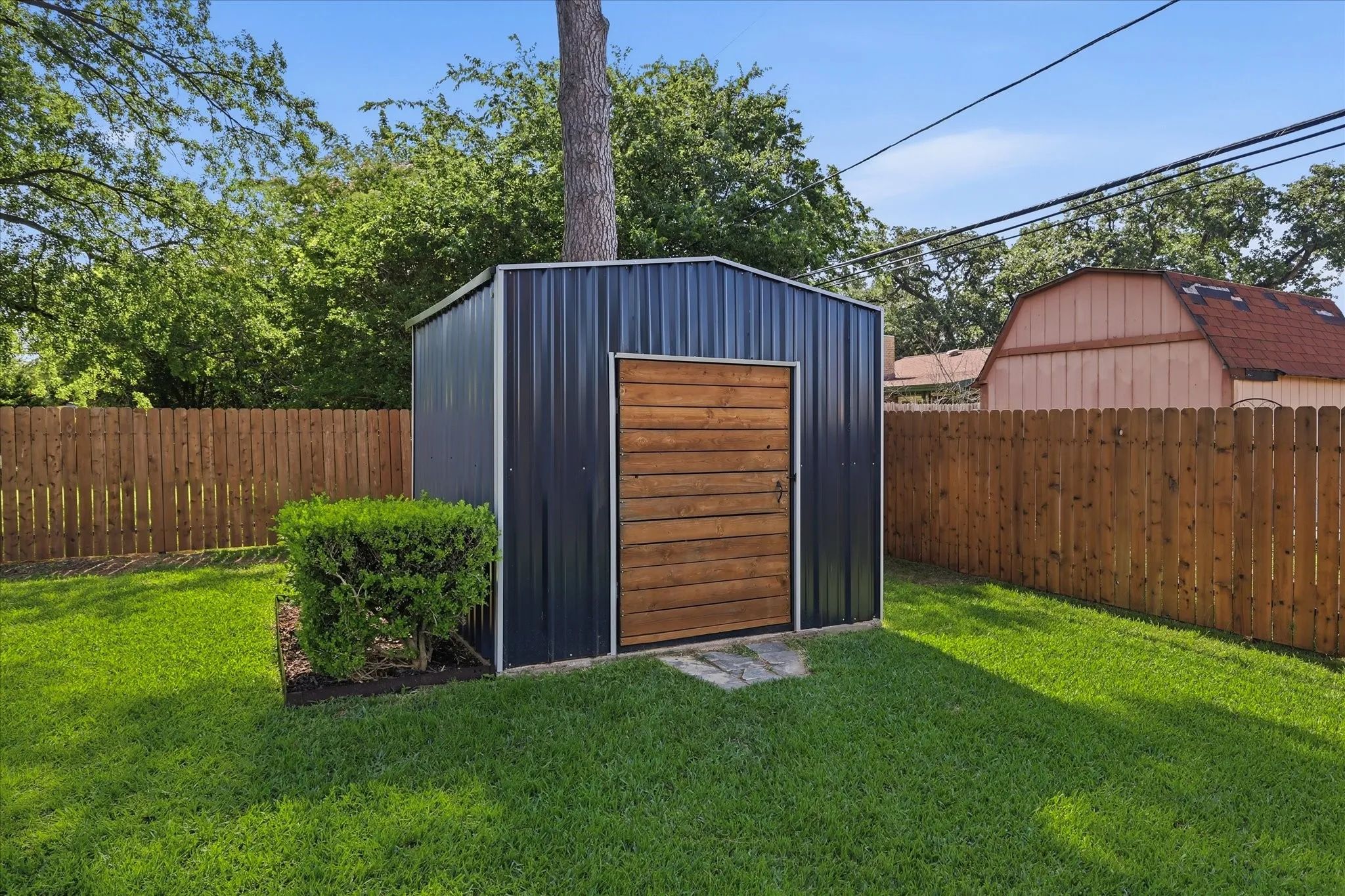 Metal storage shed with wood-panel door