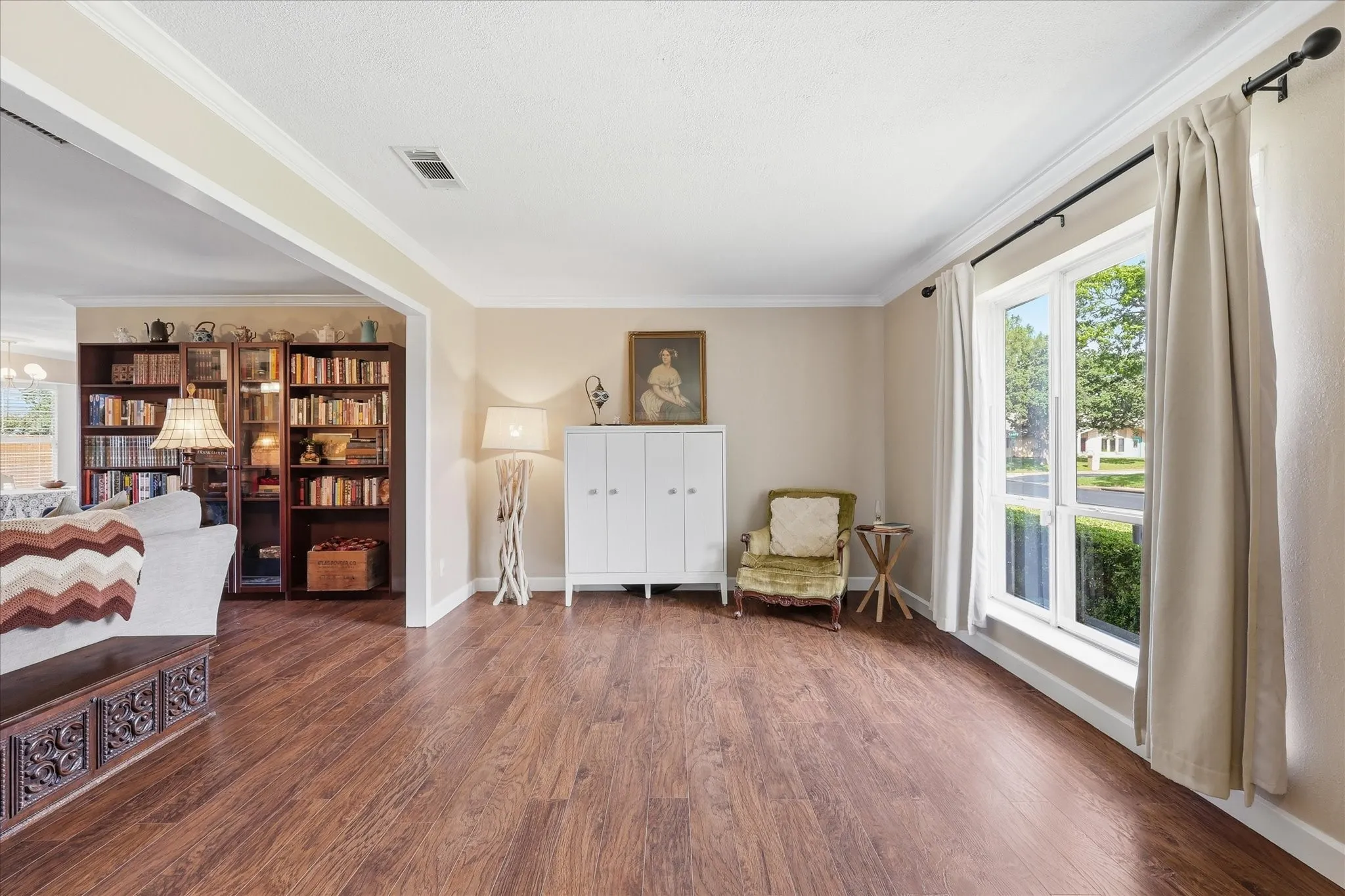 Wood-finish flooring throughout, white trim, and a large window providing ample natural light