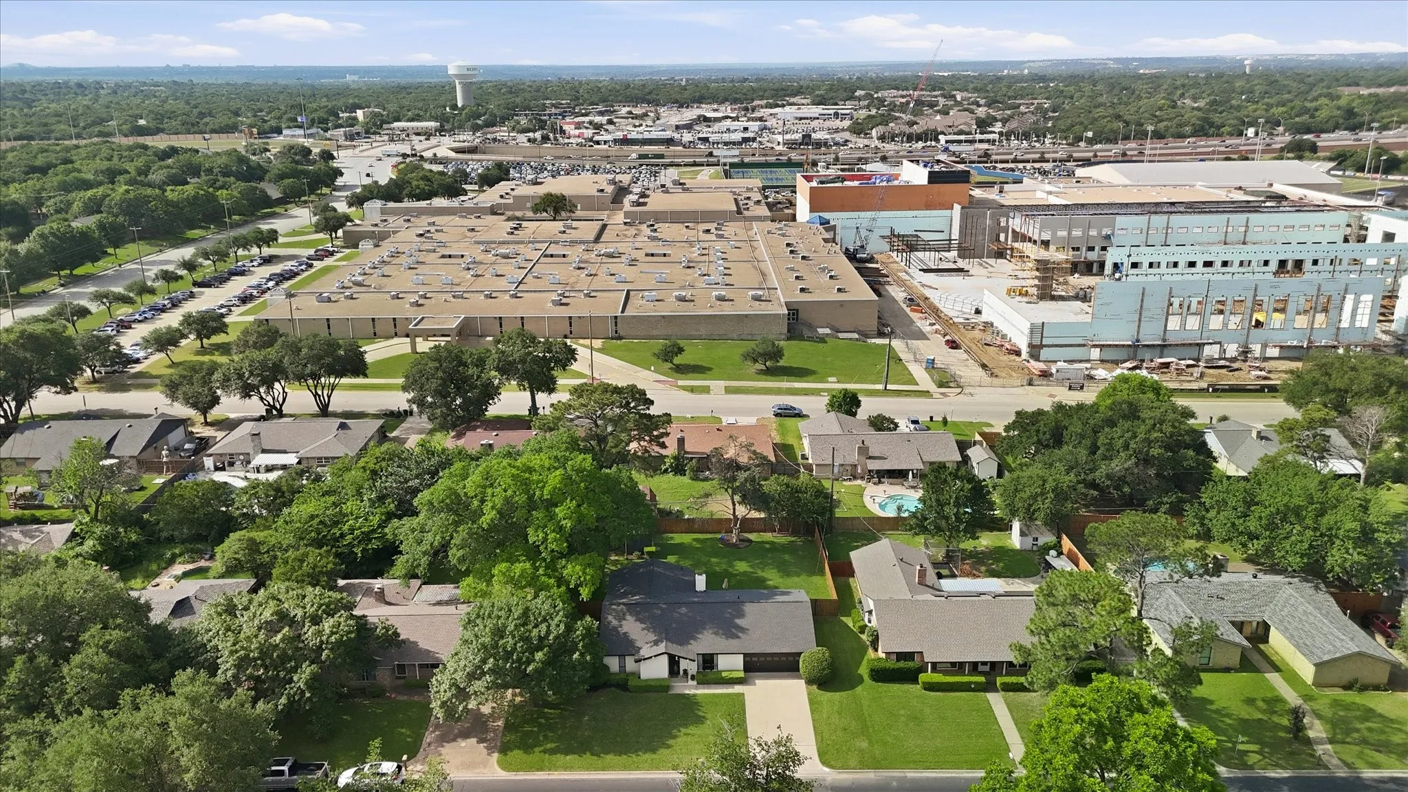 Aerial perspective of a residential area with established trees and surrounding commercial structures