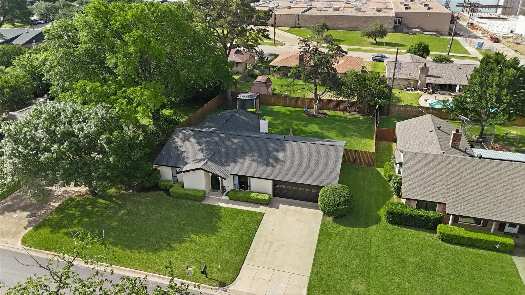 Residential property featuring a concrete driveway, attached garage, and a charcoal shingle roof
