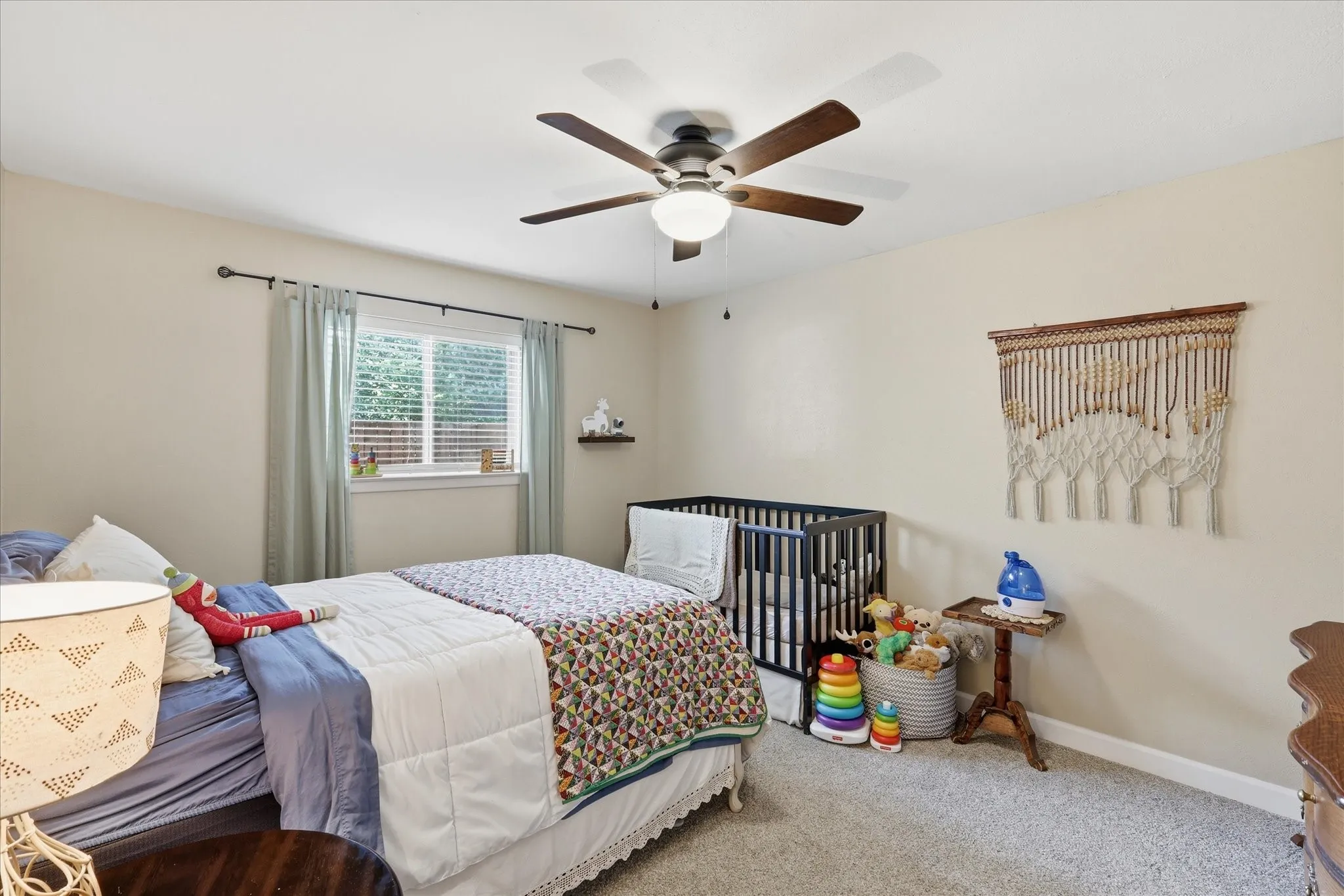Recessed window with blinds, ceiling fan with integrated lighting, wall-mounted floating shelf, and neutral wall paint finish