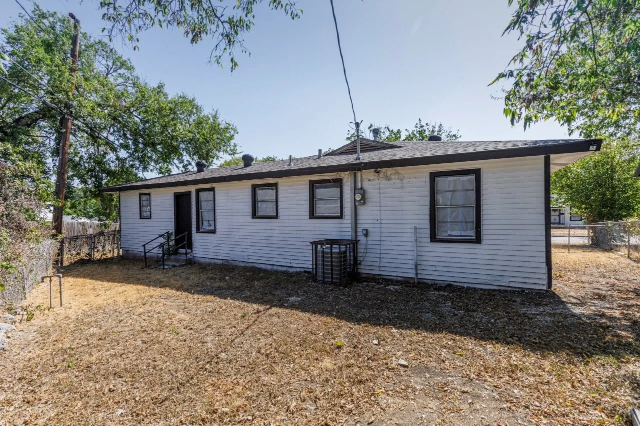 White siding exterior with black trim windows, a dark roof, and a visible HVAC unit