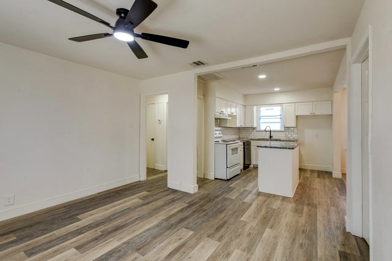 Wood-finish flooring throughout, with a modern ceiling fan