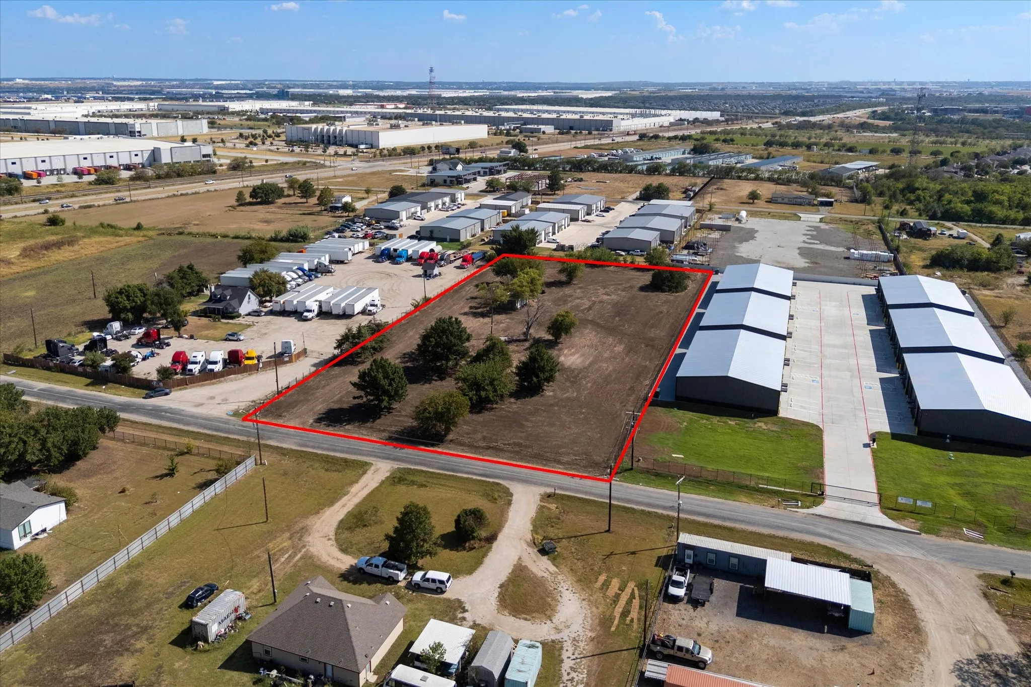 Expansive land parcel featuring clear ground and scattered mature trees