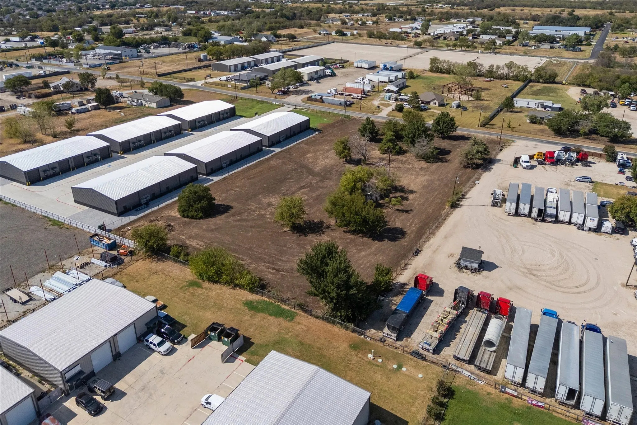 Multiple metal-clad industrial buildings with roll-up doors and substantial paved parking areas