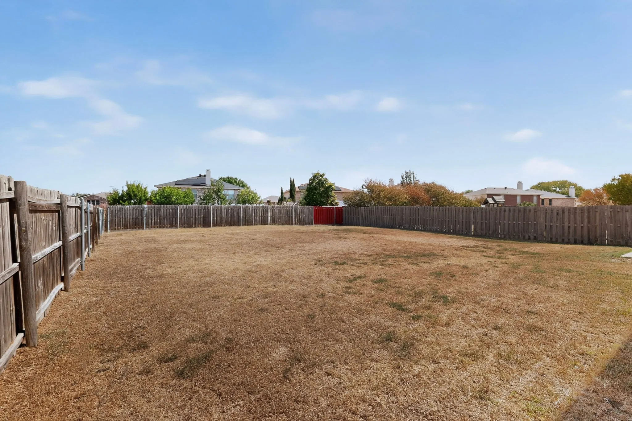 Expansive backyard area with a full privacy fence