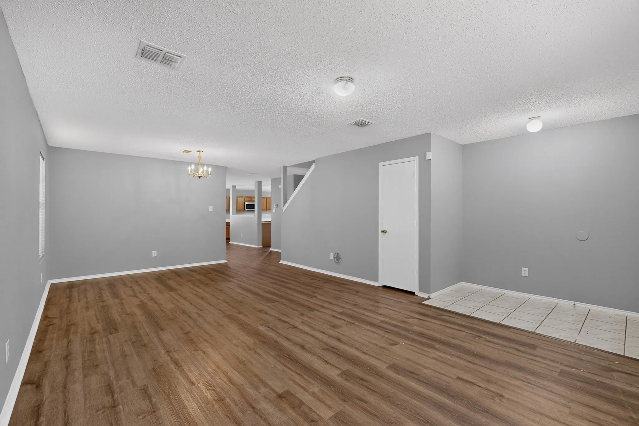 Wood-finish flooring, light gray wall paint, and white trim throughout