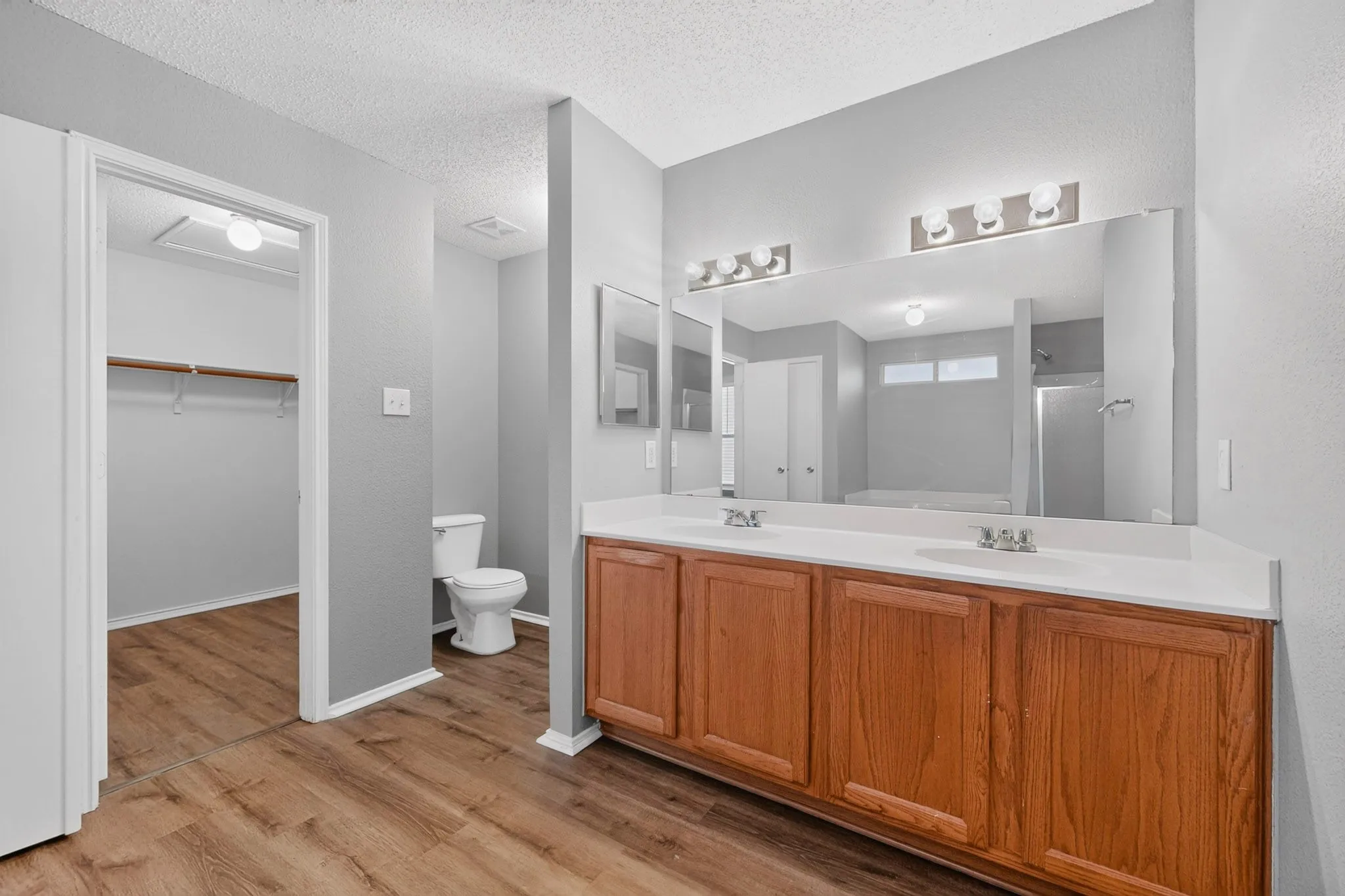 Dual vanity with wood-finish cabinetry and white countertops