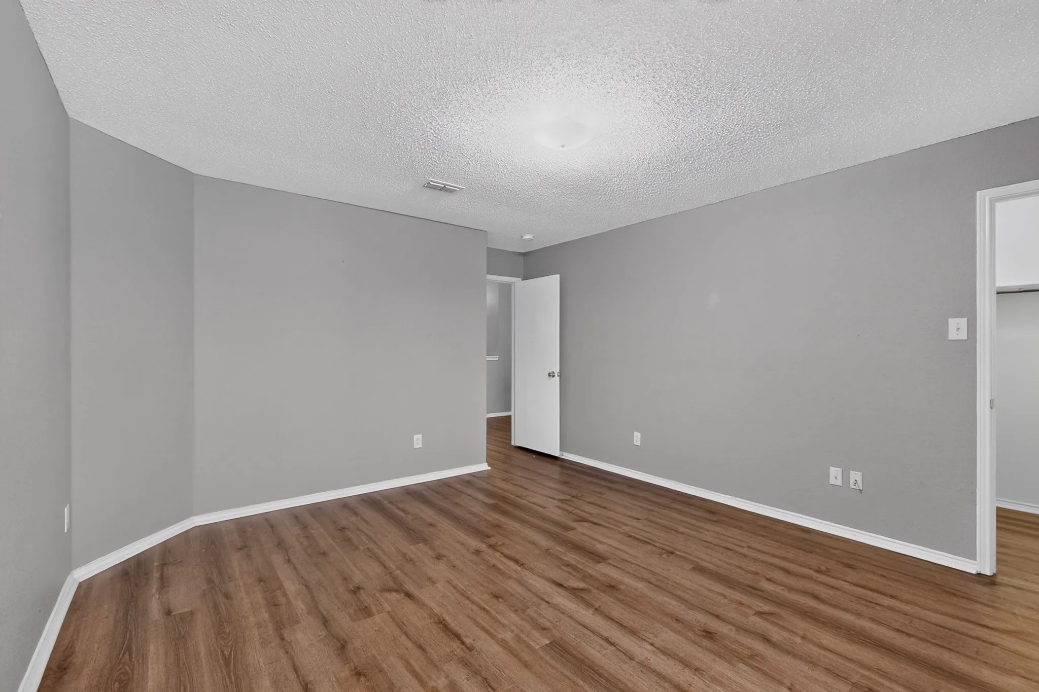 Wood-finish flooring, light gray wall paint, and white trim throughout