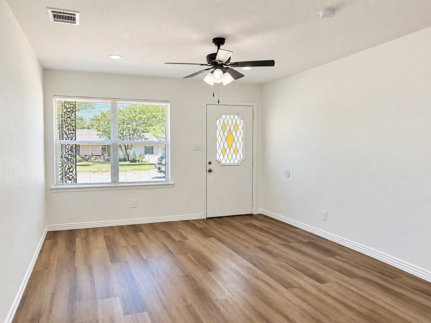 Wood-finish flooring, recessed lighting, and a ceiling fan with integrated illumination