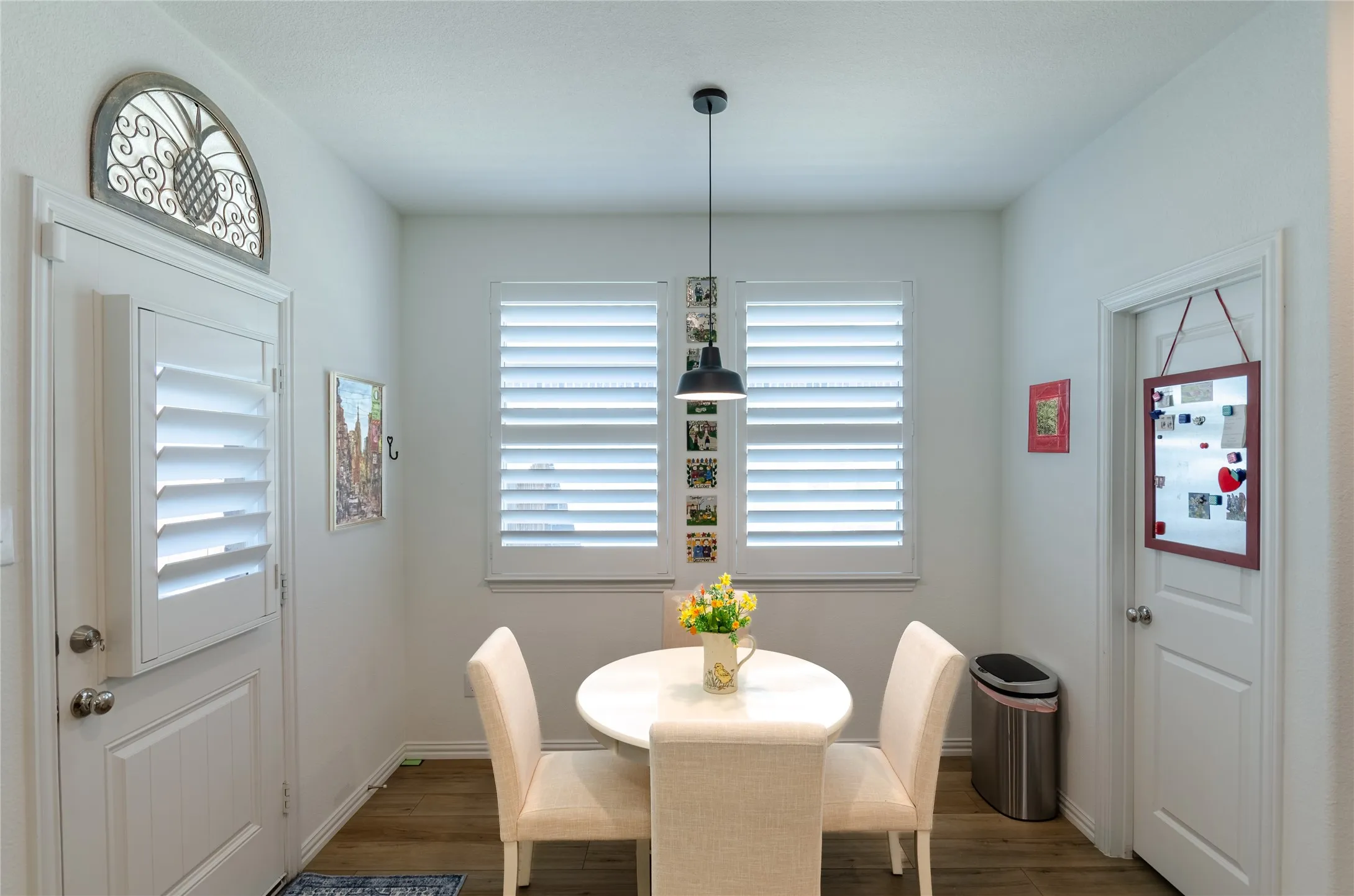 Ceiling fan with integrated lighting, window with white plantation shutters, gray carpeting, and light-colored wall paint