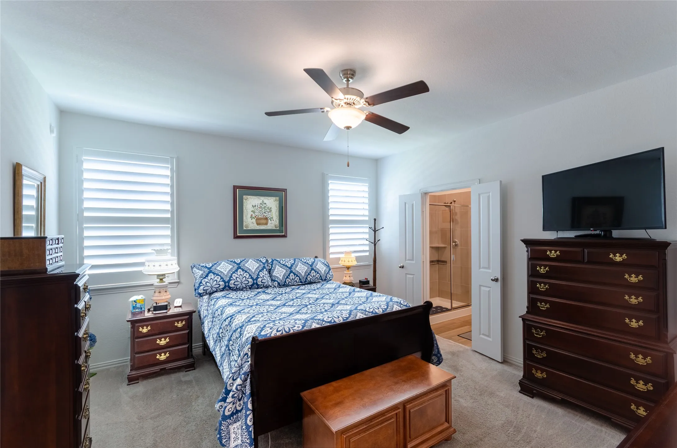 White walls, textured carpeting, and a ceiling fan with integrated lighting