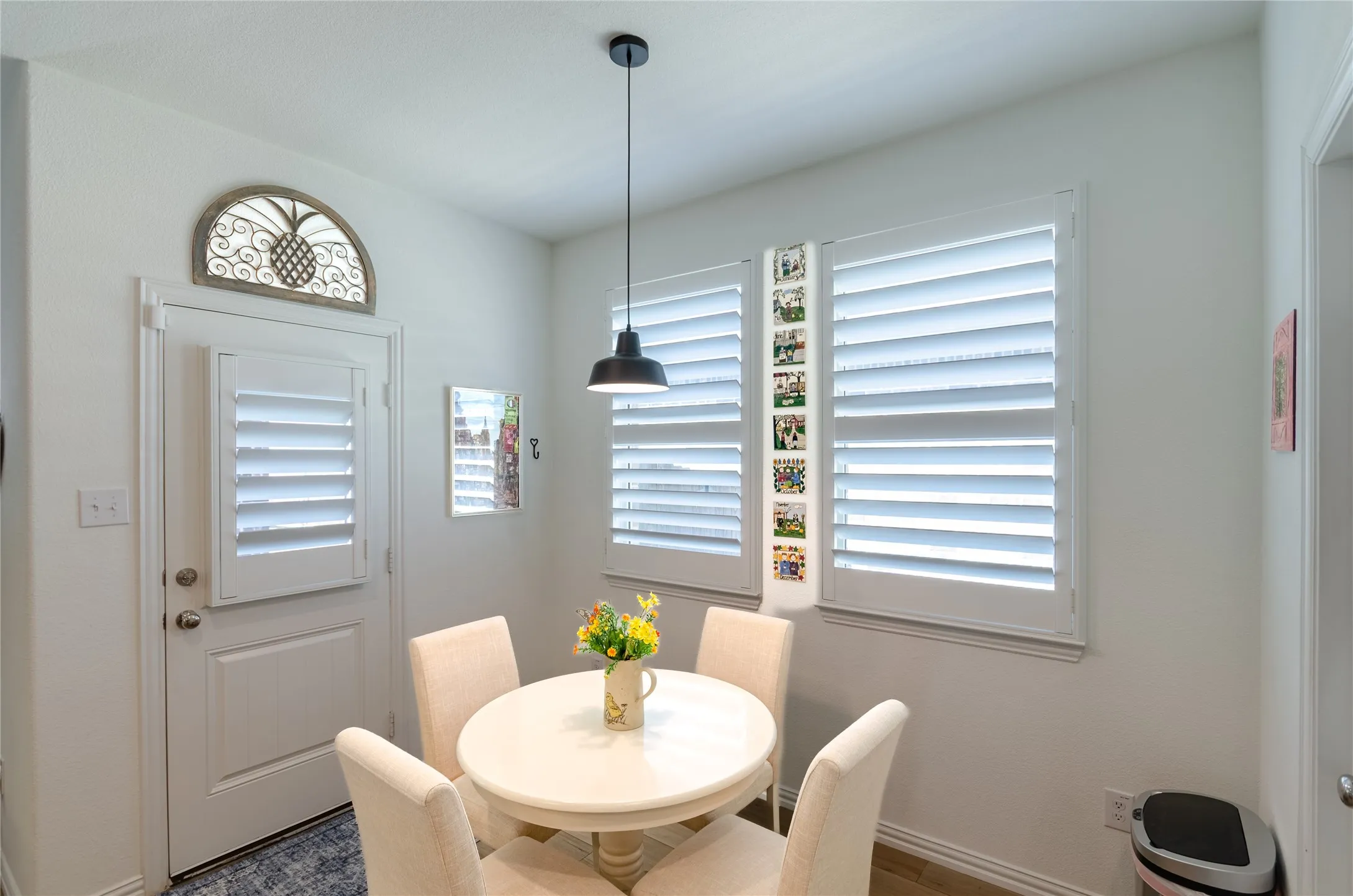 Wood-finish flooring with white walls and dual pendant light fixtures
