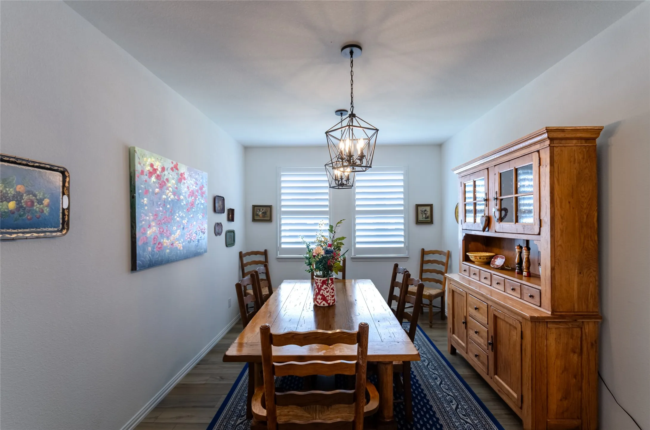 Kitchen featuring a central island with a stone countertop, stainless steel appliances, white cabinetry with crown molding, wood-finish flooring, and recessed lighting