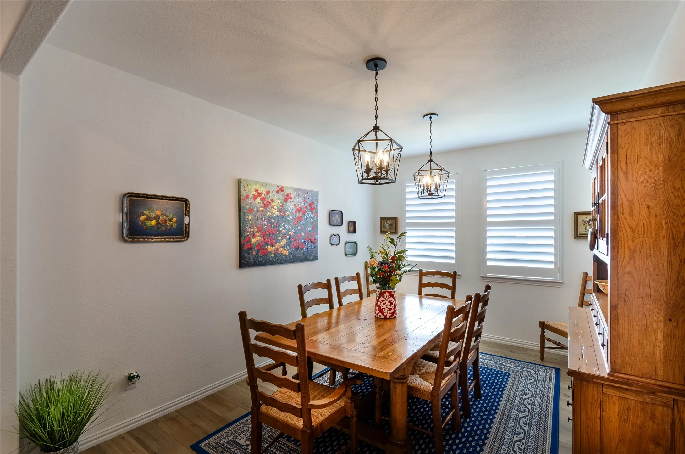 Wood-finish flooring, white walls, and a multi-light geometric chandelier