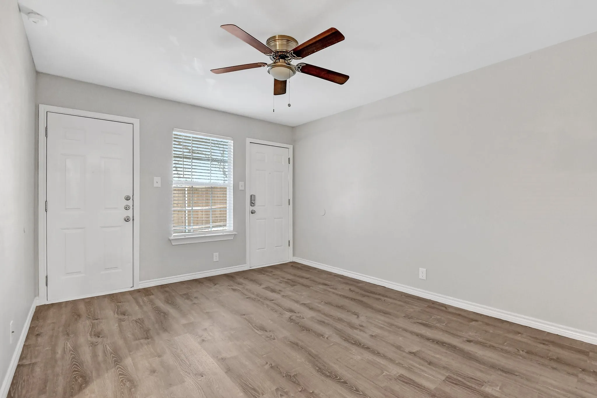 Empty room featuring baseboards, a ceiling fan, and wood finished floors
