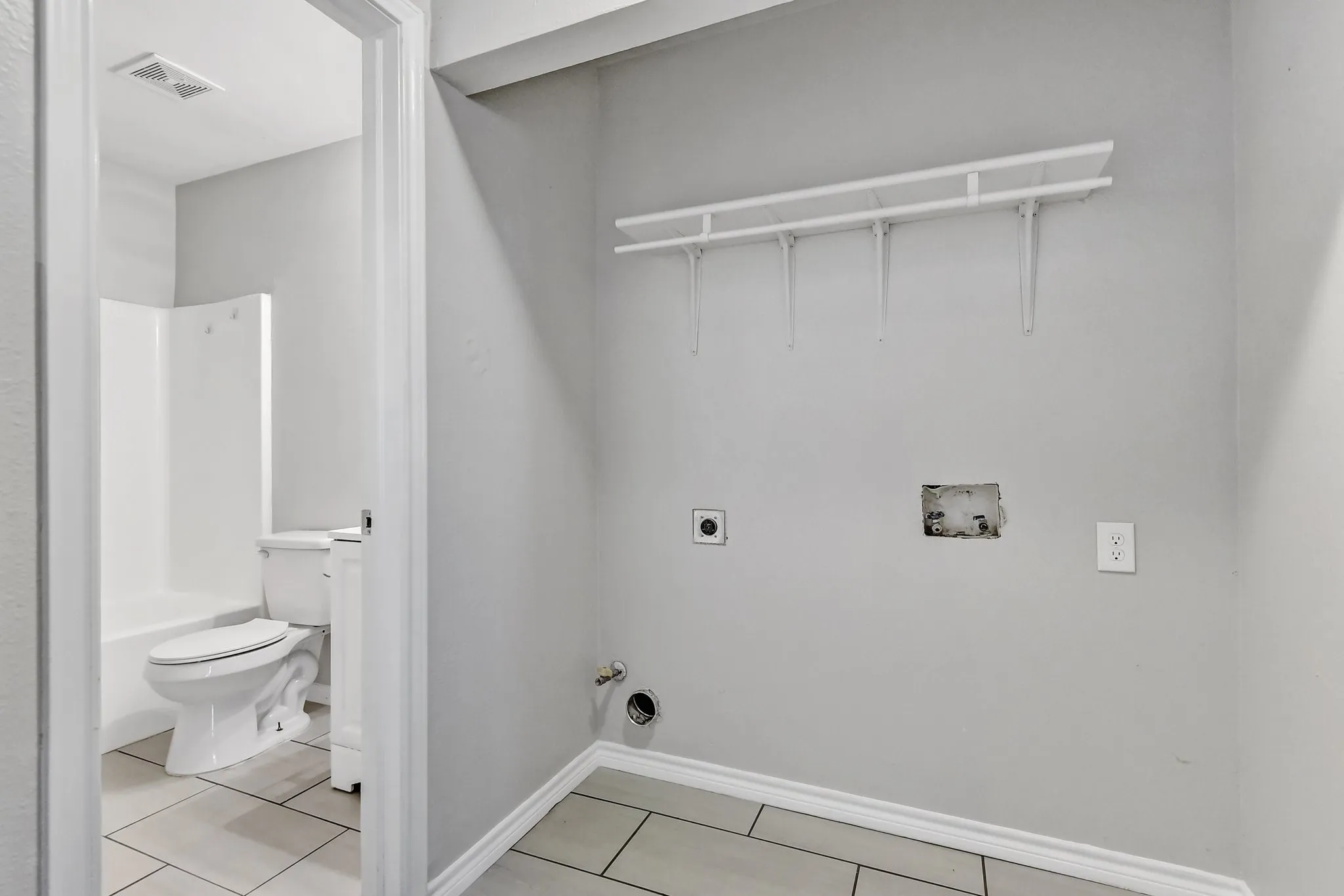 Laundry room featuring gas dryer hookup, electric dryer hookup, visible vents, light tile patterned floors, and hookup for a washing machine