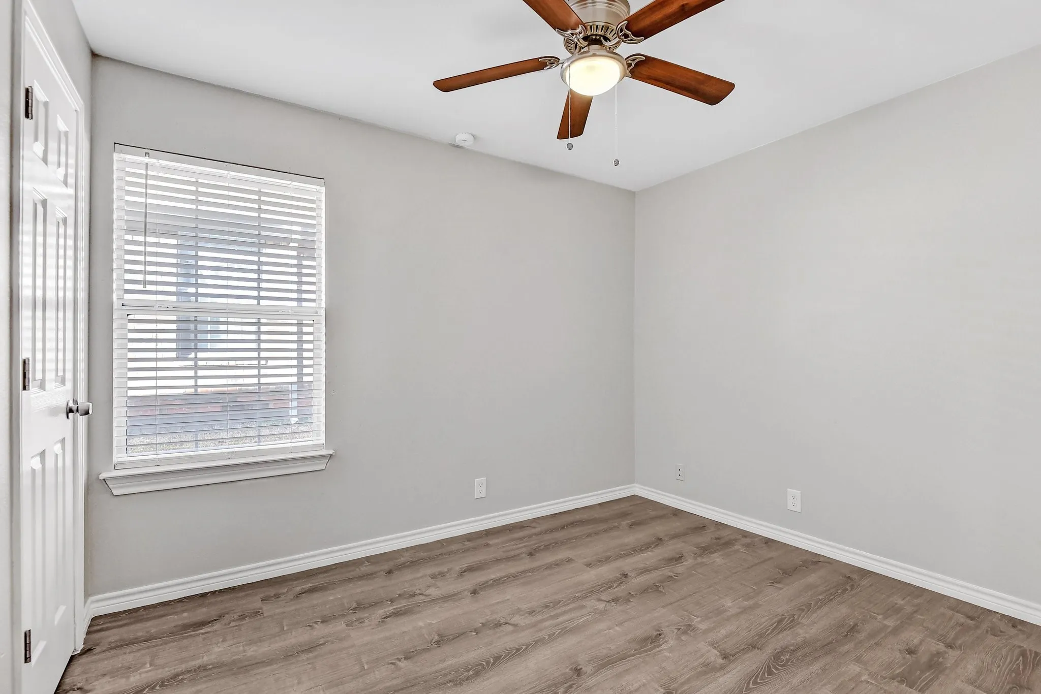 Spare room featuring baseboards, ceiling fan, and wood finished floors
