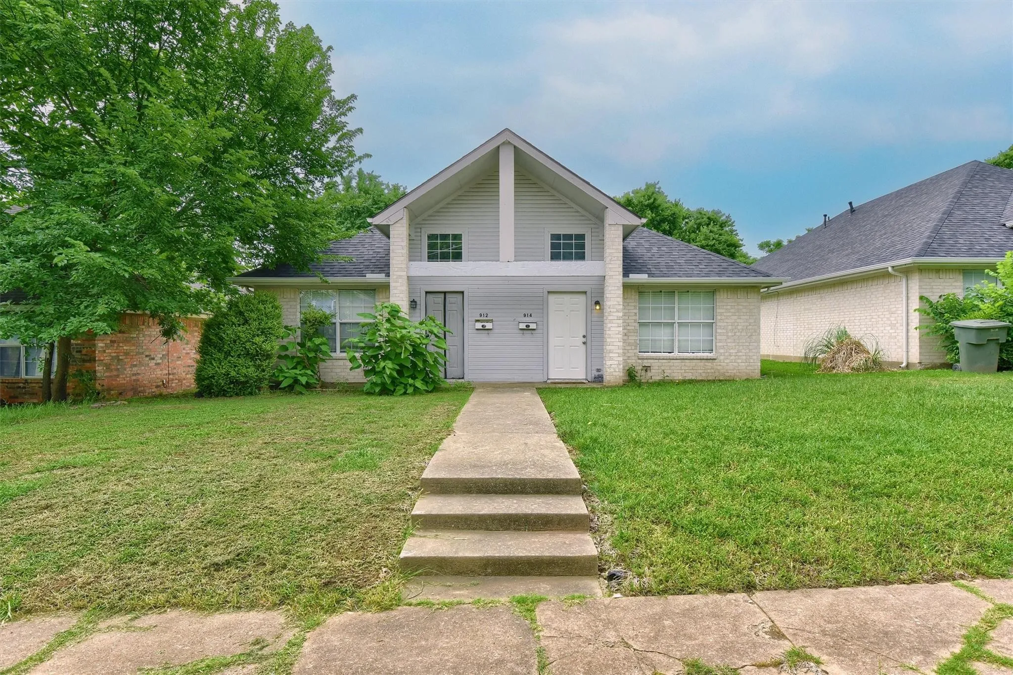 Mid-century home with a shingled roof, a front lawn, and brick siding