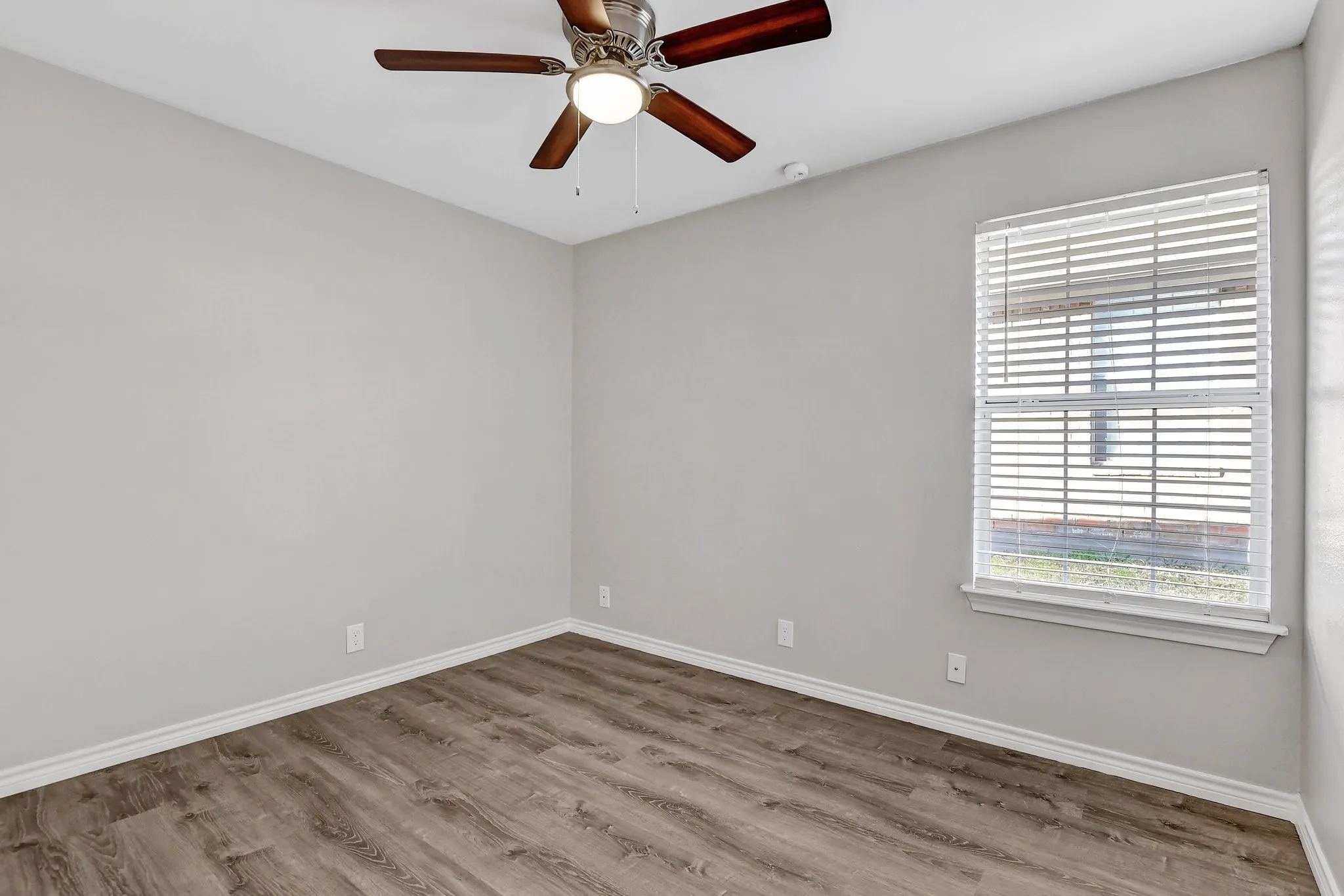 Spare room featuring baseboards, ceiling fan, and wood finished floors