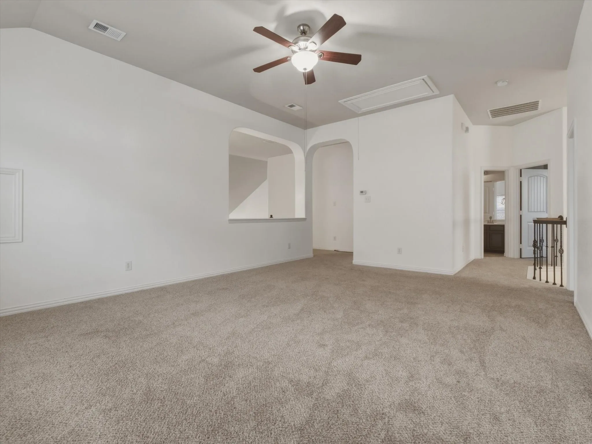 Expansive game room featuring neutral carpet flooring, a ceiling fan with light fixture