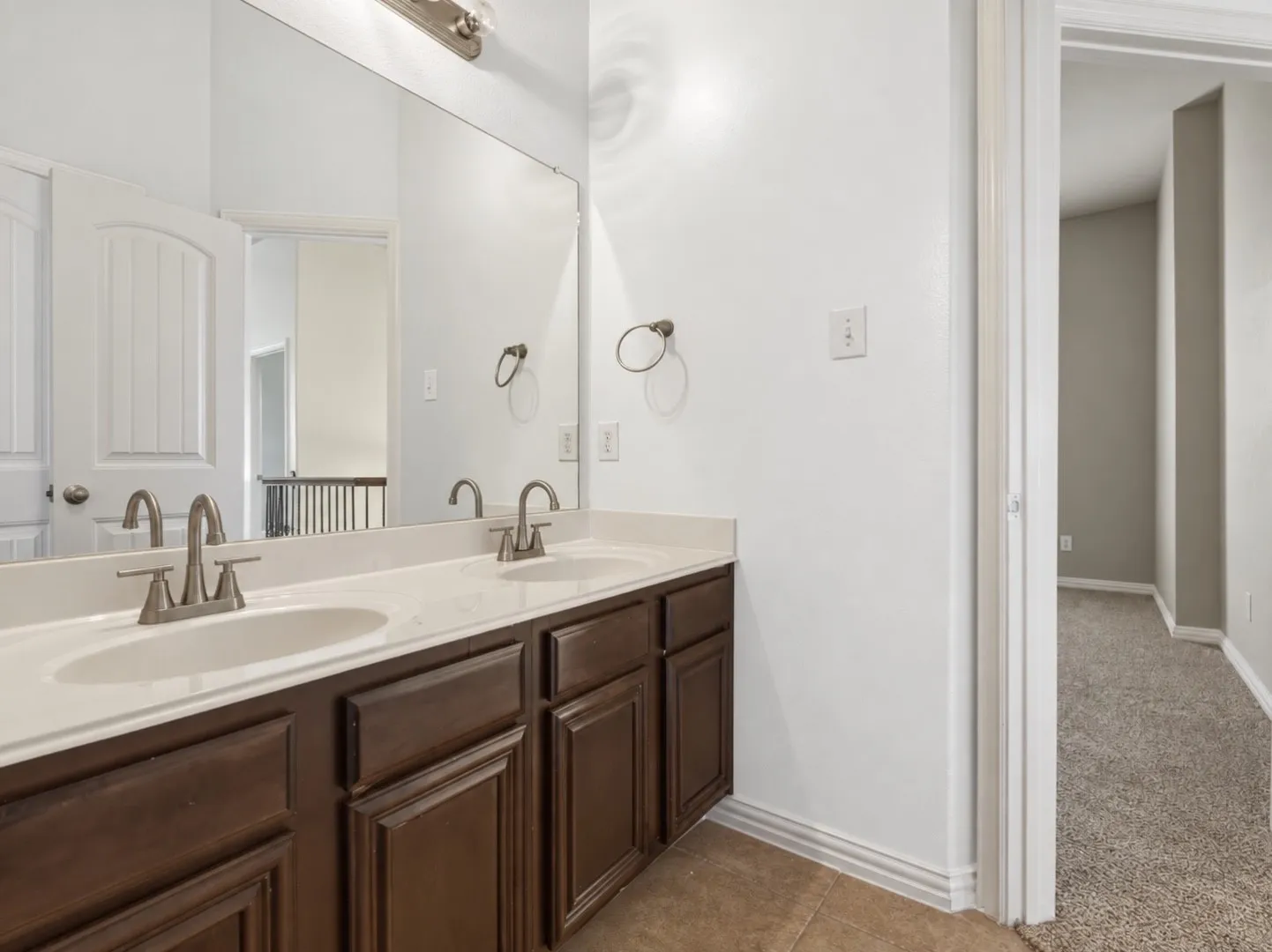 Dual vanity with a stone-finish countertop, undermount sinks, and brushed nickel fixtures