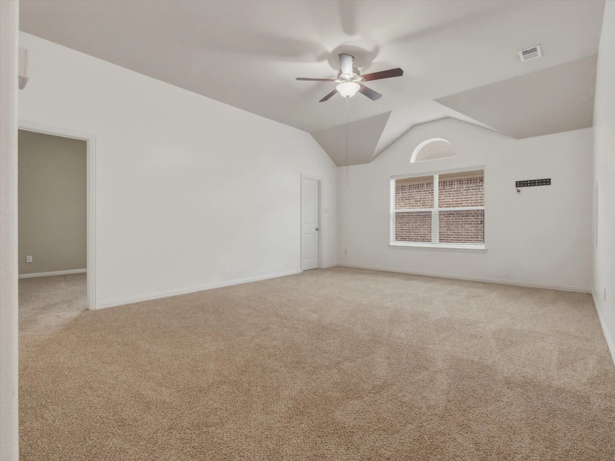 Spacious room featuring carpet flooring, a ceiling fan, and a window