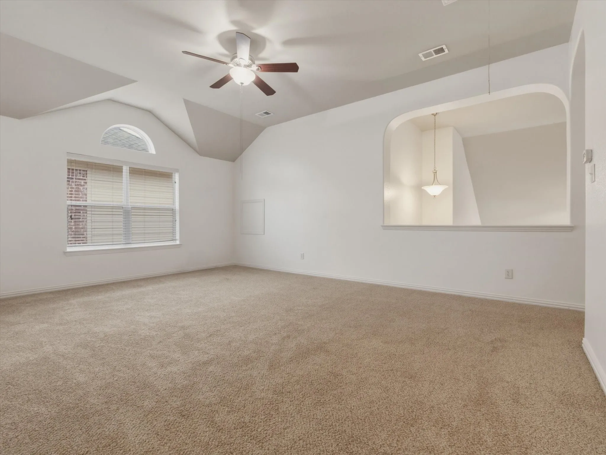Expansive game room featuring neutral carpet flooring, a ceiling fan with light fixture