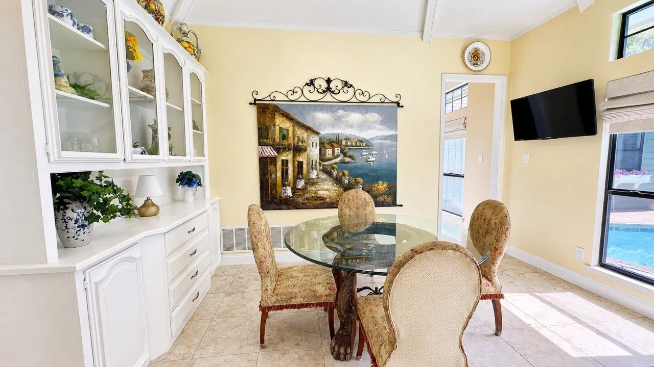 Charming separate breakfast room with hutch overlooks the pool.