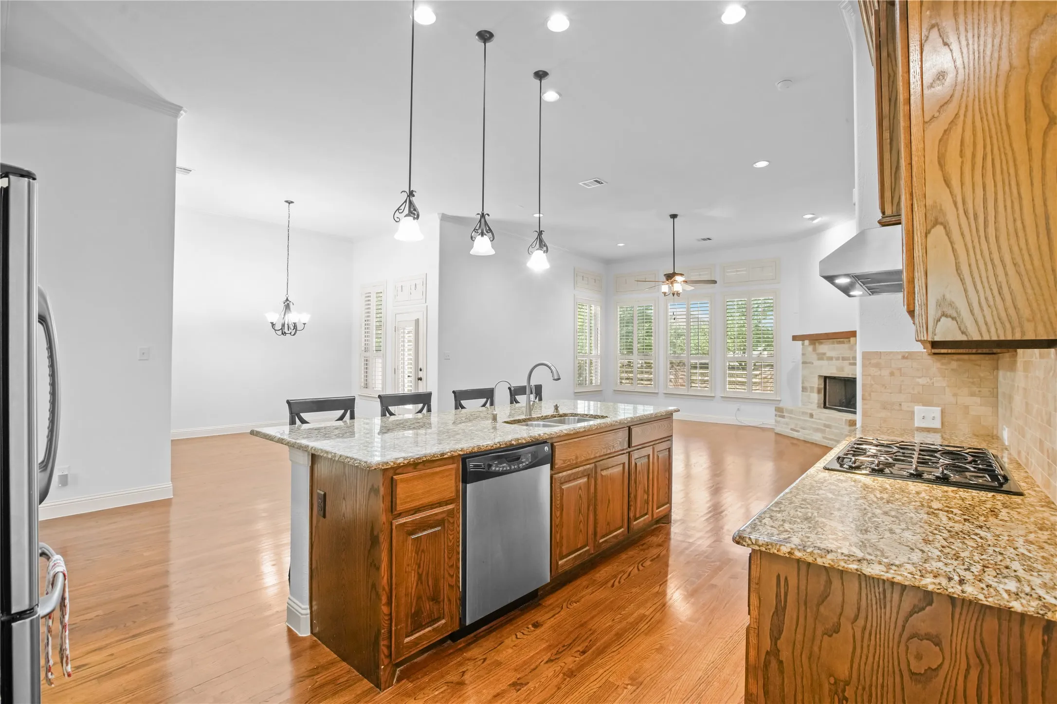 Kitchen island with integrated sink, stainless steel dishwasher, and bar seating