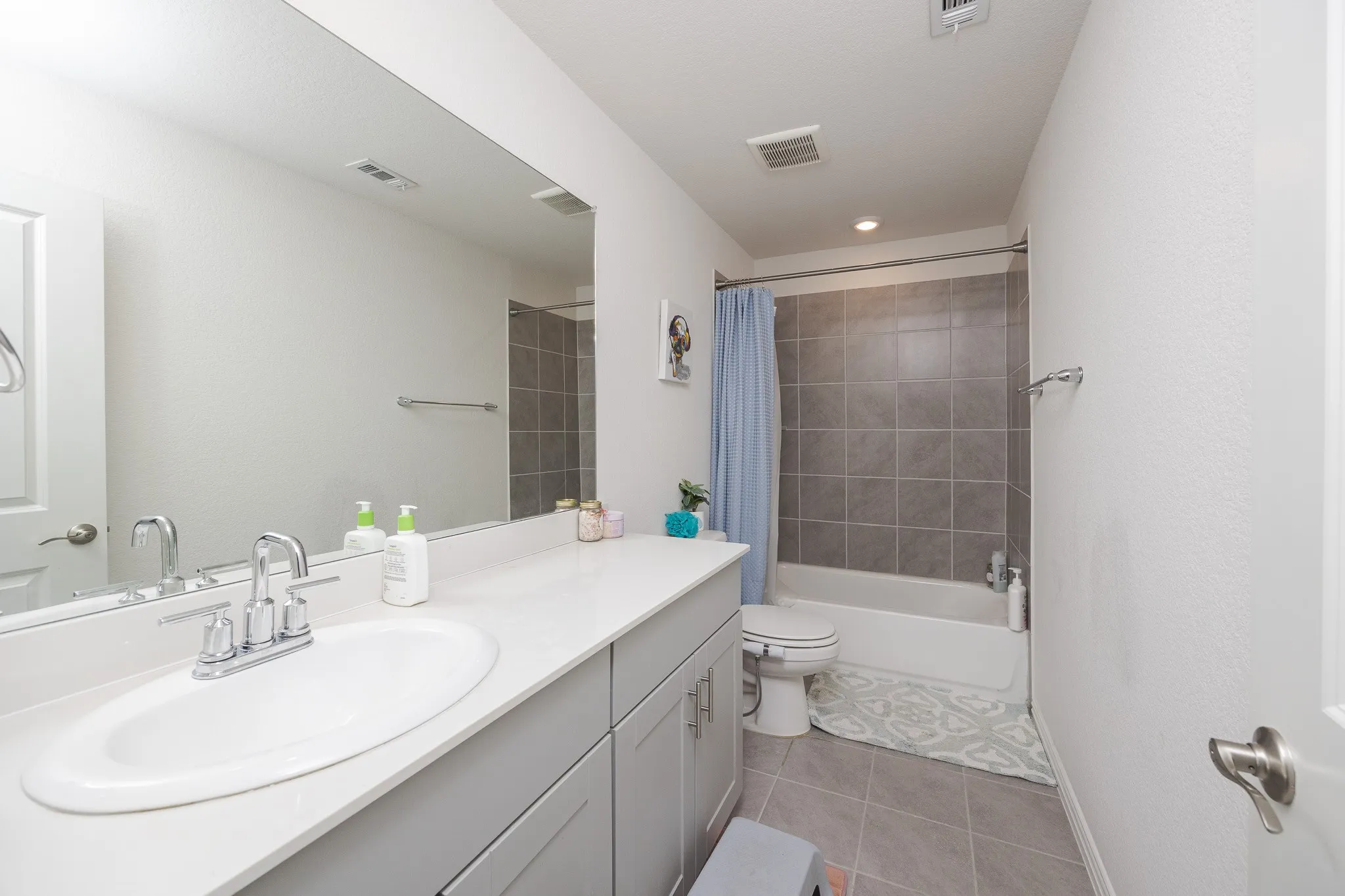 Full vanity with an integrated sink, polished chrome faucet, and quartz-finish countertop