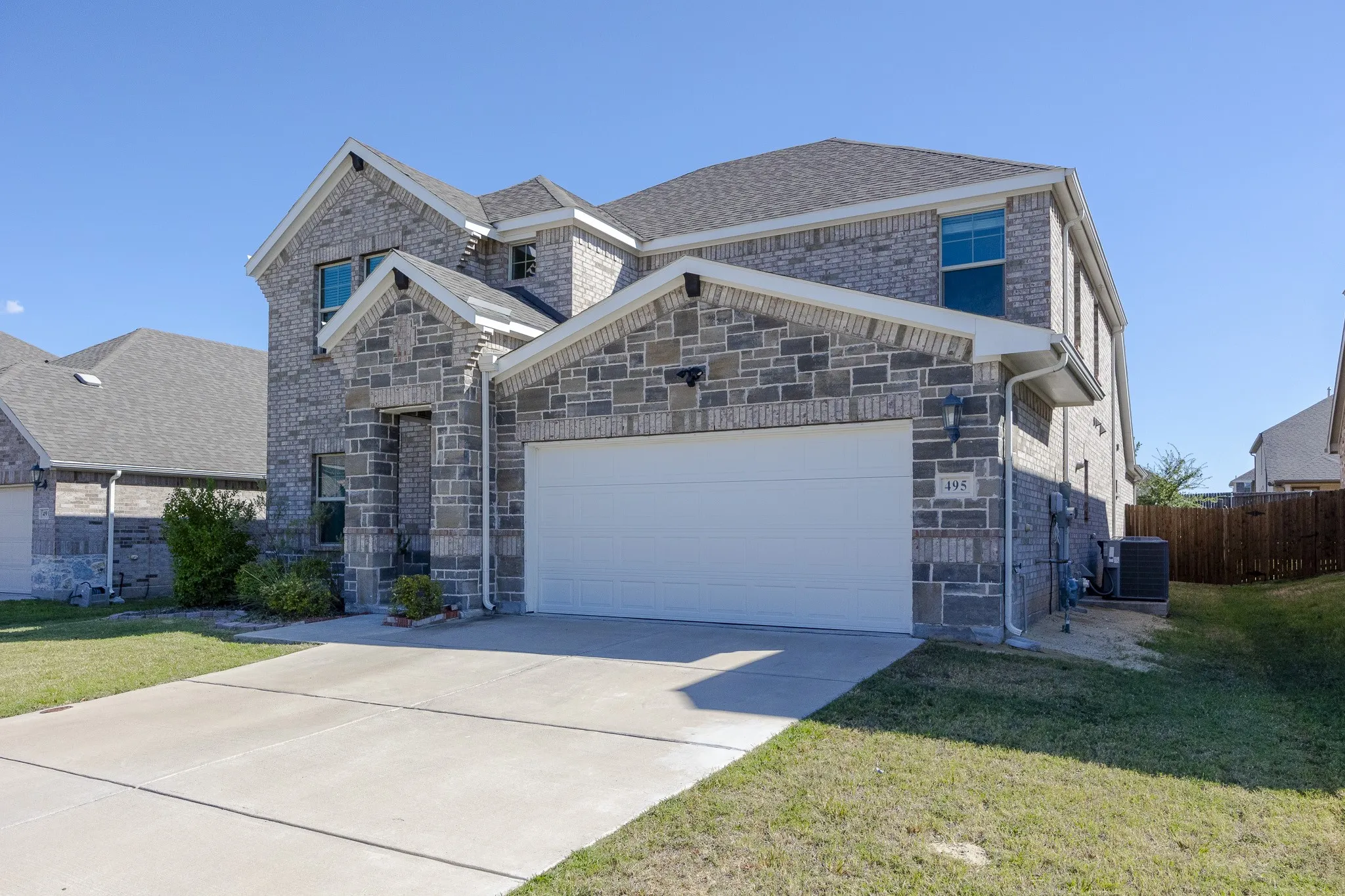 Stone and brick exterior with a two-car garage