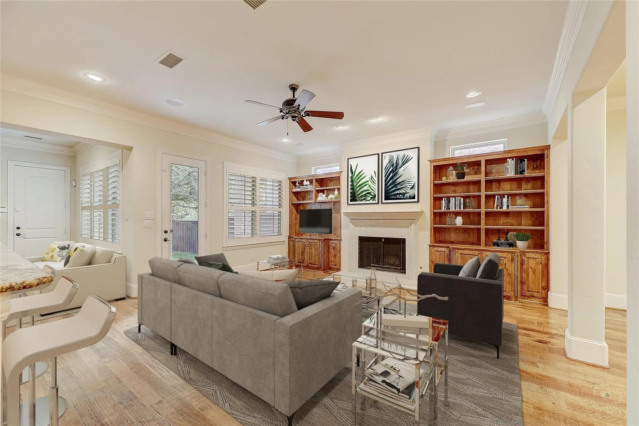 Spacious living area featuring wood-finish flooring, a ceiling fan, recessed lighting, and a fireplace with a stone surround