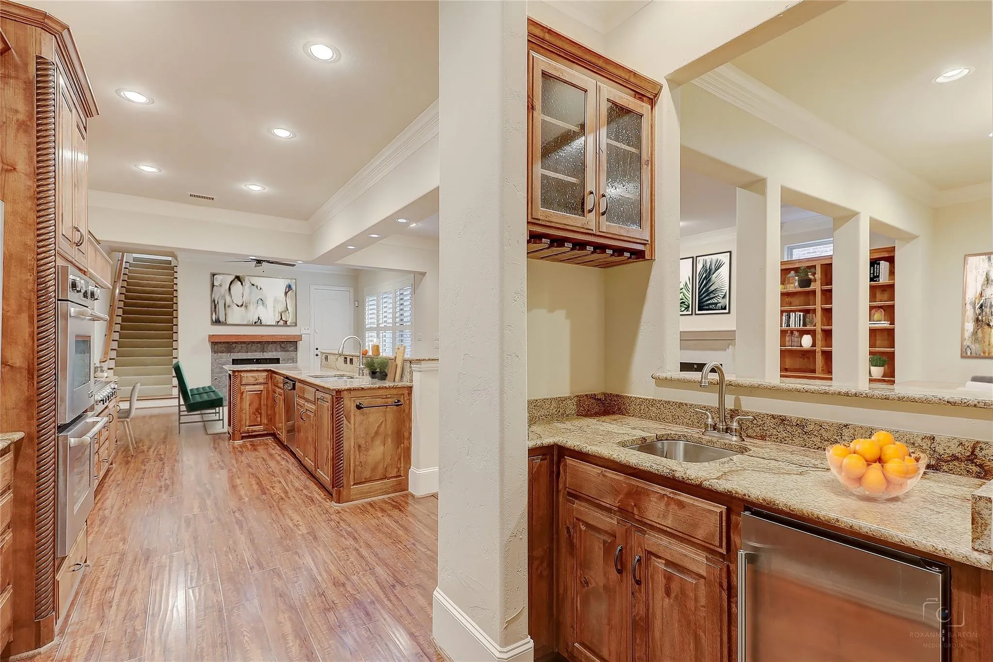 Gourmet kitchen with wood-finish flooring, stainless steel appliances, and an expansive island