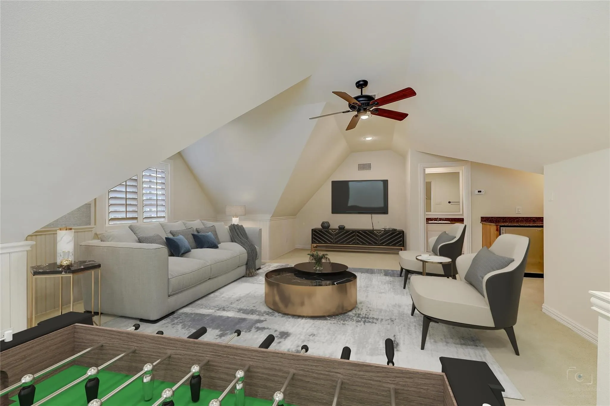 Spacious dormer room featuring sloped ceilings, window with plantation shutters, ceiling fan, and built-in wet bar with a compact refrigerator
