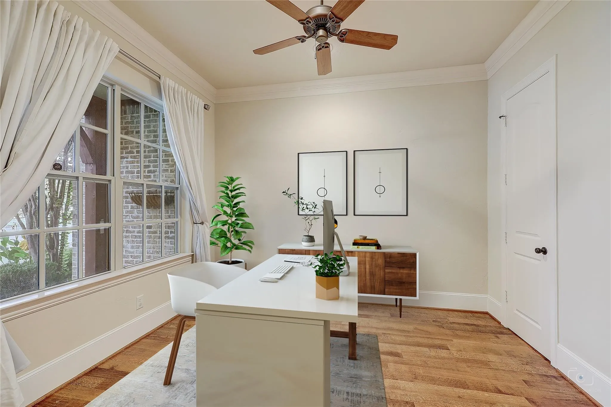 Wood-finish flooring, crown molding, and a ceiling fan with wood-finish blades