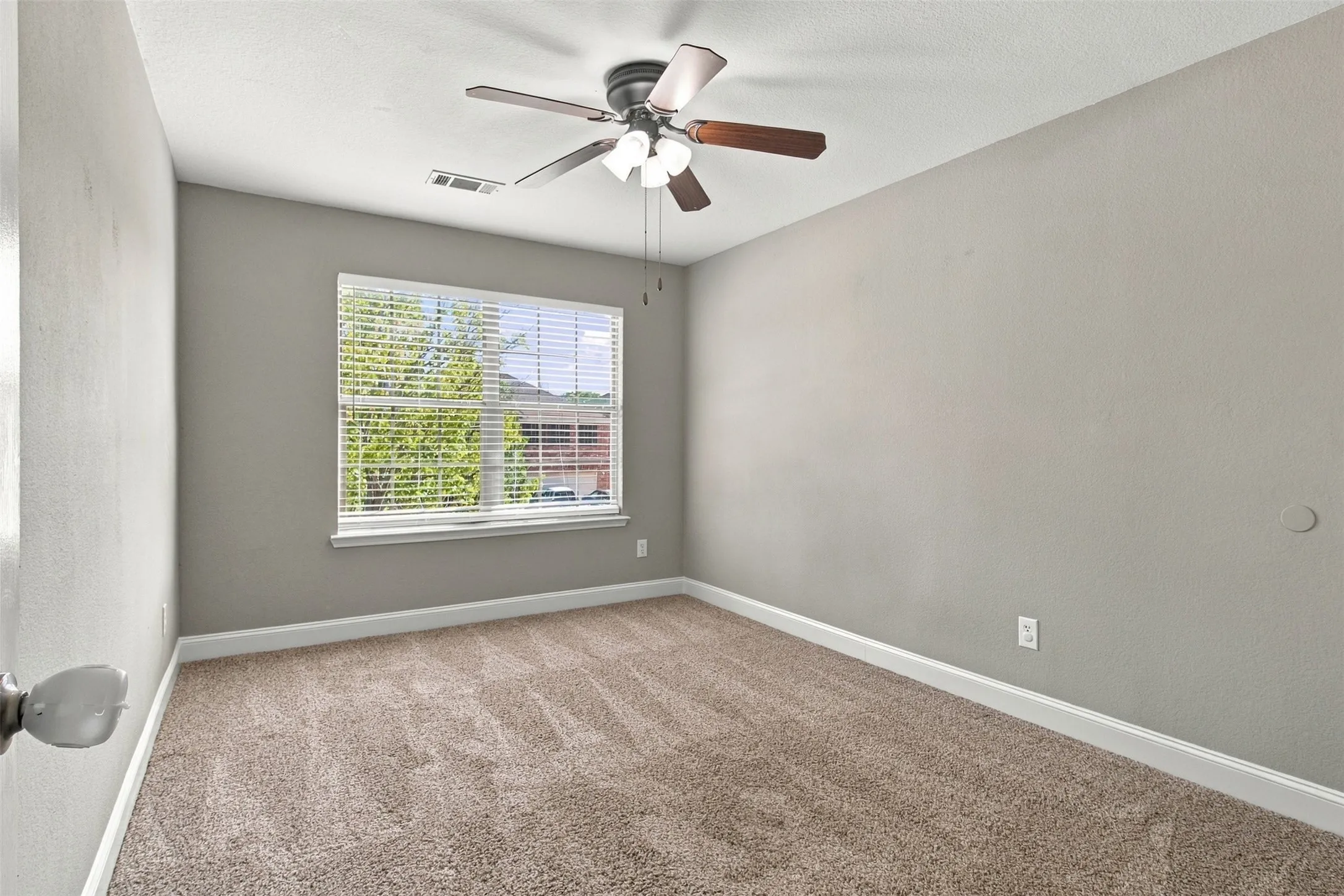 Recessed ceiling fan with integrated lighting, window with blinds, light-toned wall paint, white trim, and carpeted flooring